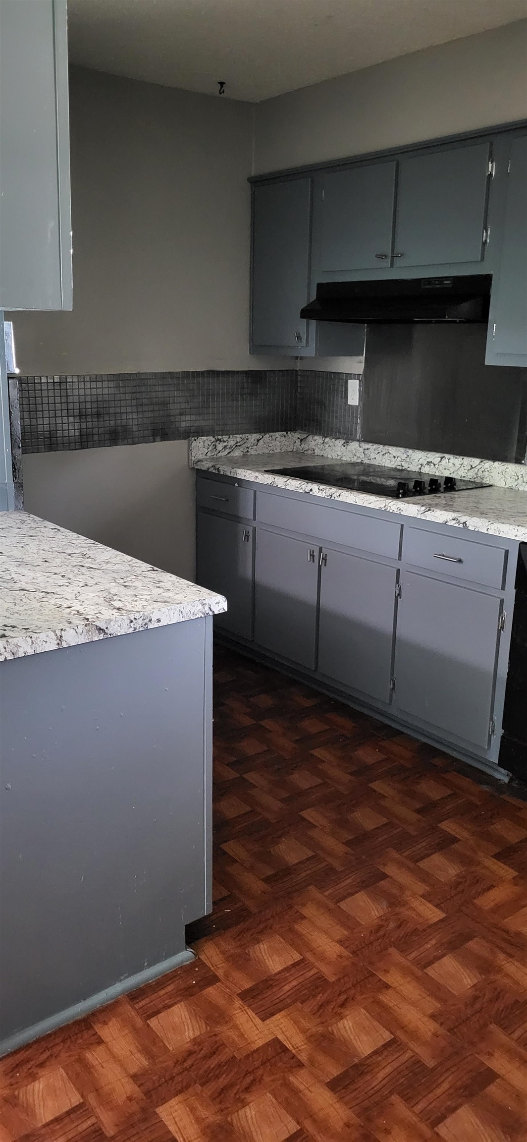4567 Crump Road Memphis, TN 38141 - Photo 27 of 28 Kitchen featuring under cabinet range hood, black electric cooktop, gray cabinetry, light countertops, and decorative backsplash