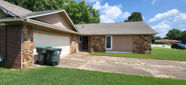 a front view of a house with a garden and yard