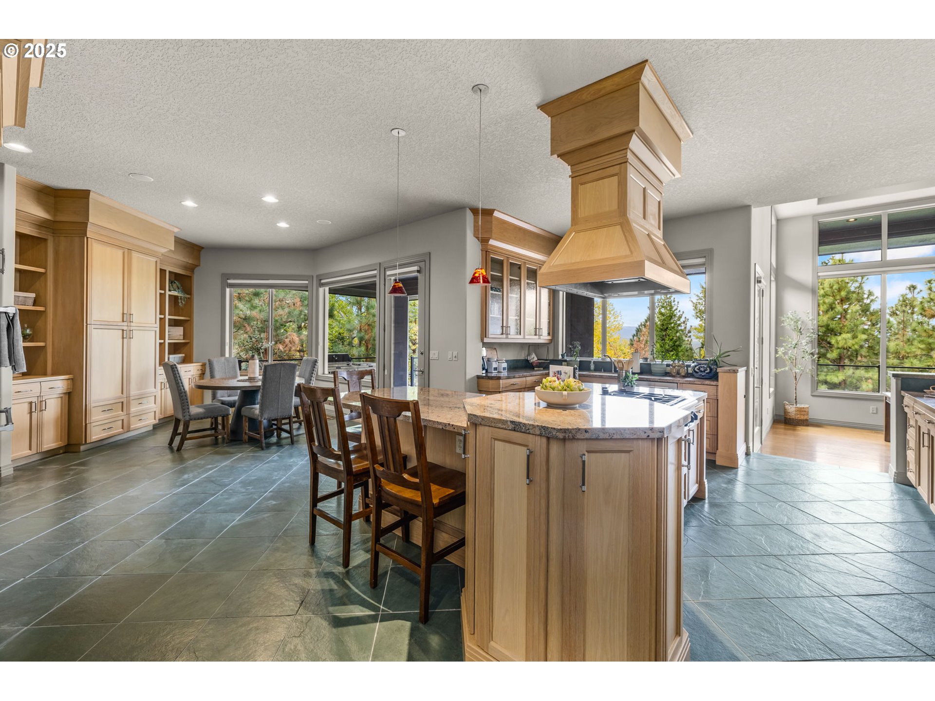 3155 Northwest Metke Place Bend, OR 97703 - Photo 14 of 28 a open kitchen with stainless steel appliances granite countertop a kitchen island a stove a table and chairs
