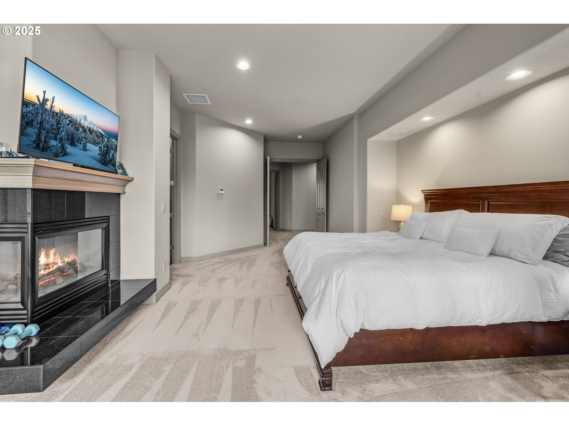 3155 Northwest Metke Place Bend, OR 97703 - Photo 20 of 28 a spacious bedroom with a bed and a fireplace