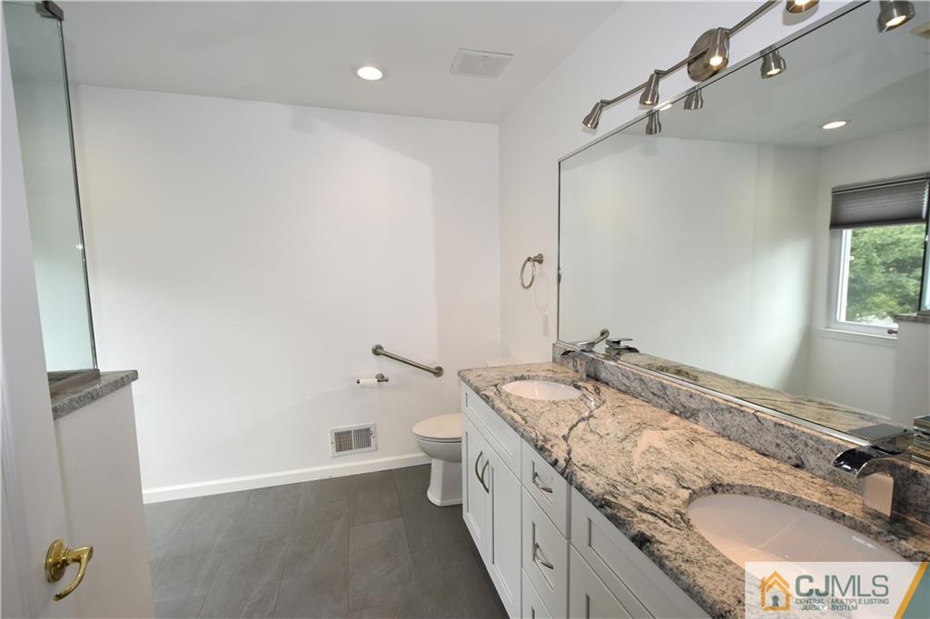 1 Timber Ridge Road North Brunswick, NJ 08902 - Photo 19 of 38 a bathroom with a granite countertop sink and a mirror