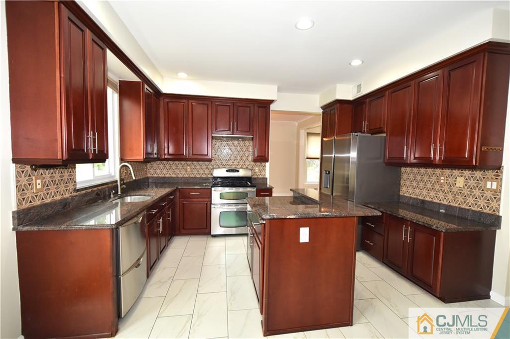 1 Timber Ridge Road North Brunswick, NJ 08902 - Photo 7 of 38 a kitchen with stainless steel appliances granite countertop a stove a refrigerator a sink and dishwasher