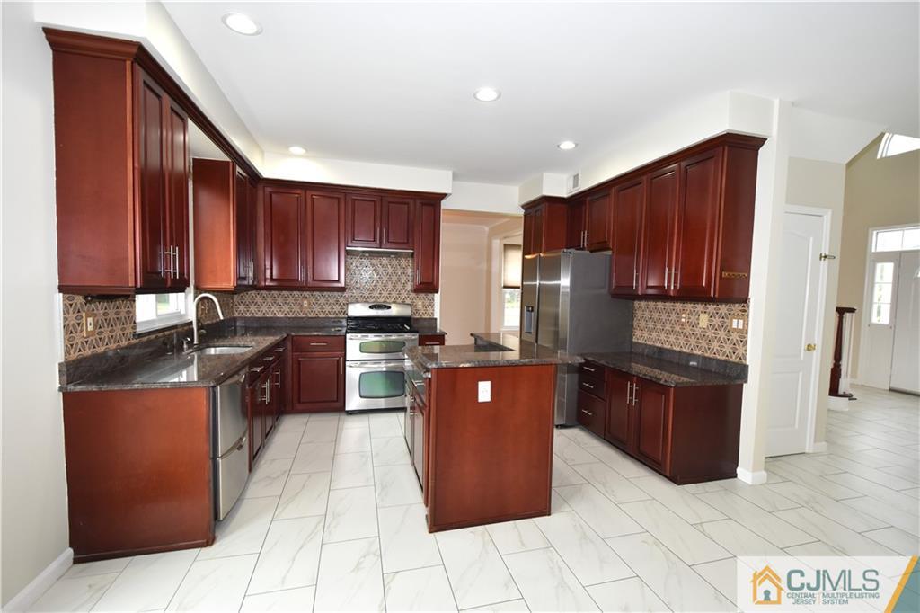 1 Timber Ridge Road North Brunswick, NJ 08902 - Photo 8 of 38 a kitchen with stainless steel appliances granite countertop wooden cabinets a stove a sink and a refrigerator