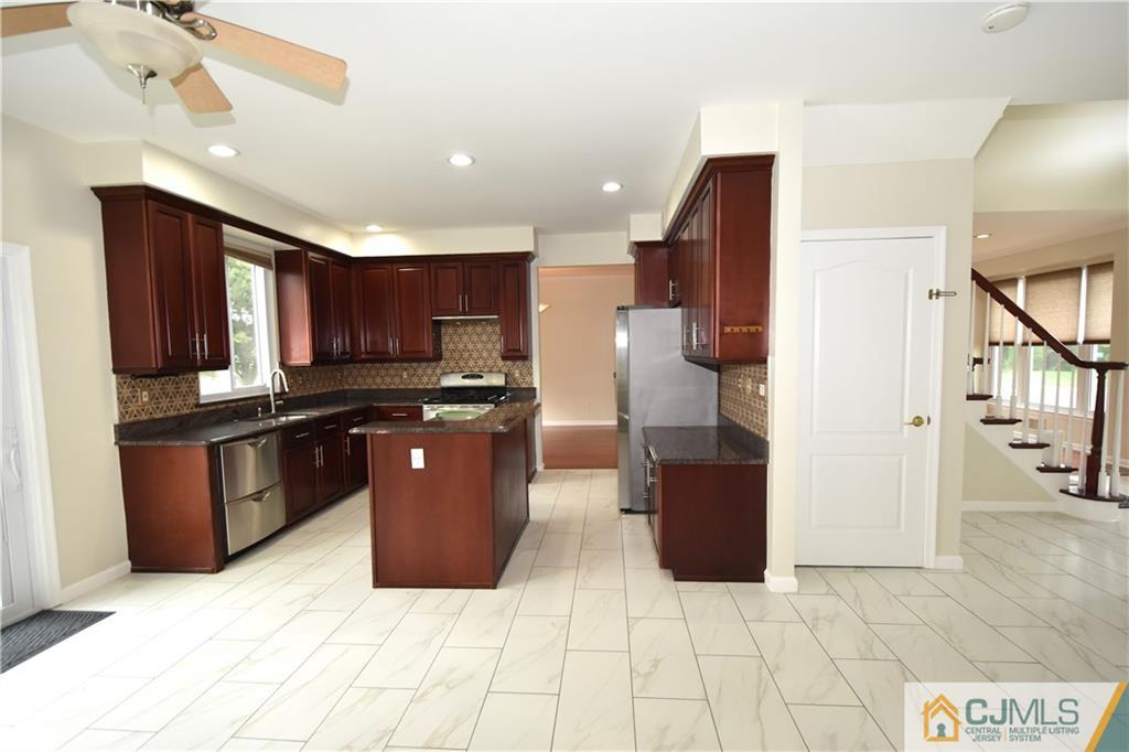 1 Timber Ridge Road North Brunswick, NJ 08902 - Photo 9 of 38 a large kitchen with stainless steel appliances kitchen island granite countertop a refrigerator and a sink