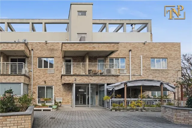 a front view of a building with parking lot of windows
