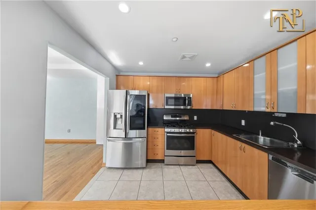 a large kitchen with stainless steel appliances kitchen island granite countertop a sink and cabinets