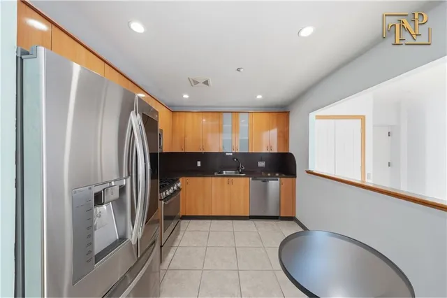 a kitchen with stainless steel appliances granite countertop a refrigerator and a stove