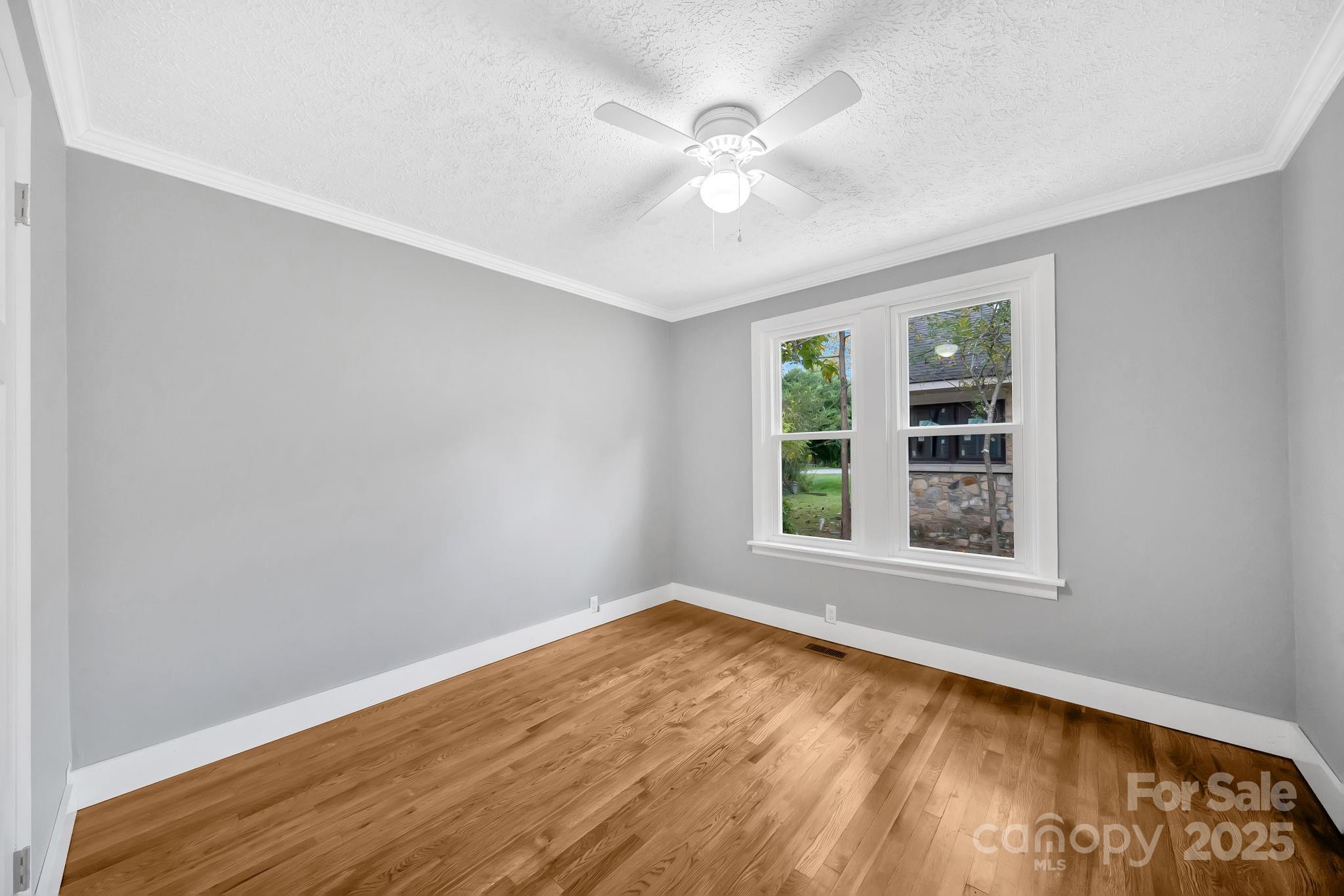 95 Whitmire Street Brevard, NC 28712 - Photo 11 of 34 wooden floor in an empty room with a window