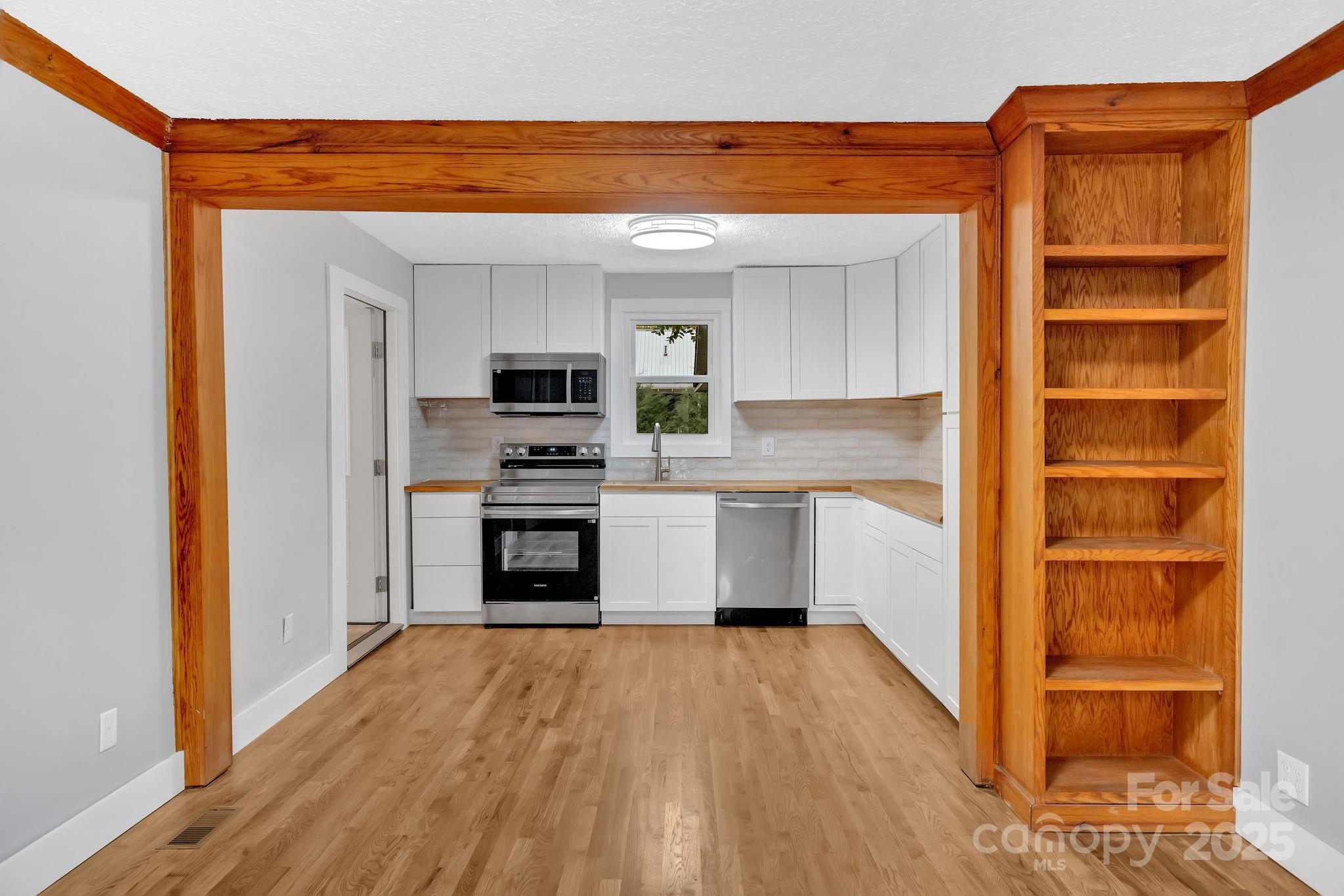 95 Whitmire Street Brevard, NC 28712 - Photo 14 of 34 a kitchen with a refrigerator and a stove top oven