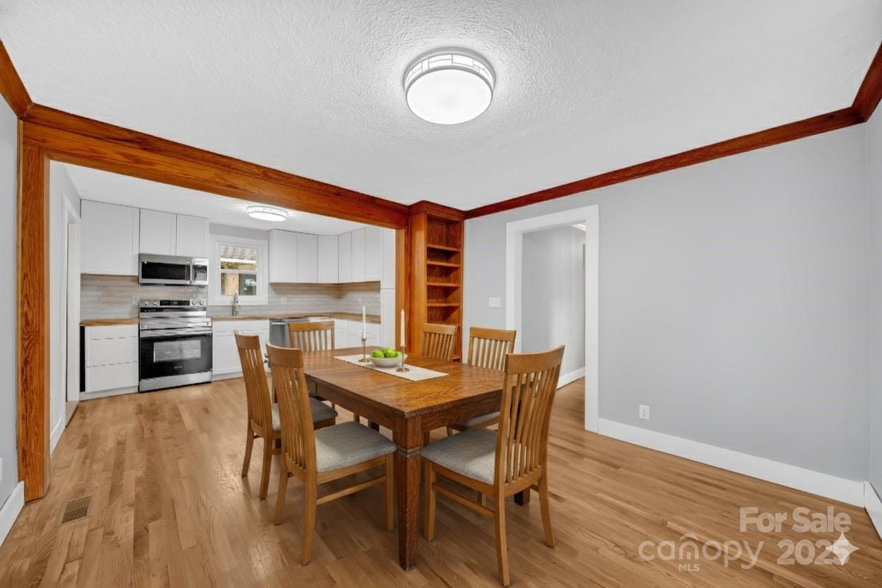 95 Whitmire Street Brevard, NC 28712 - Photo 17 of 34 a view of a dining room with furniture and wooden floor