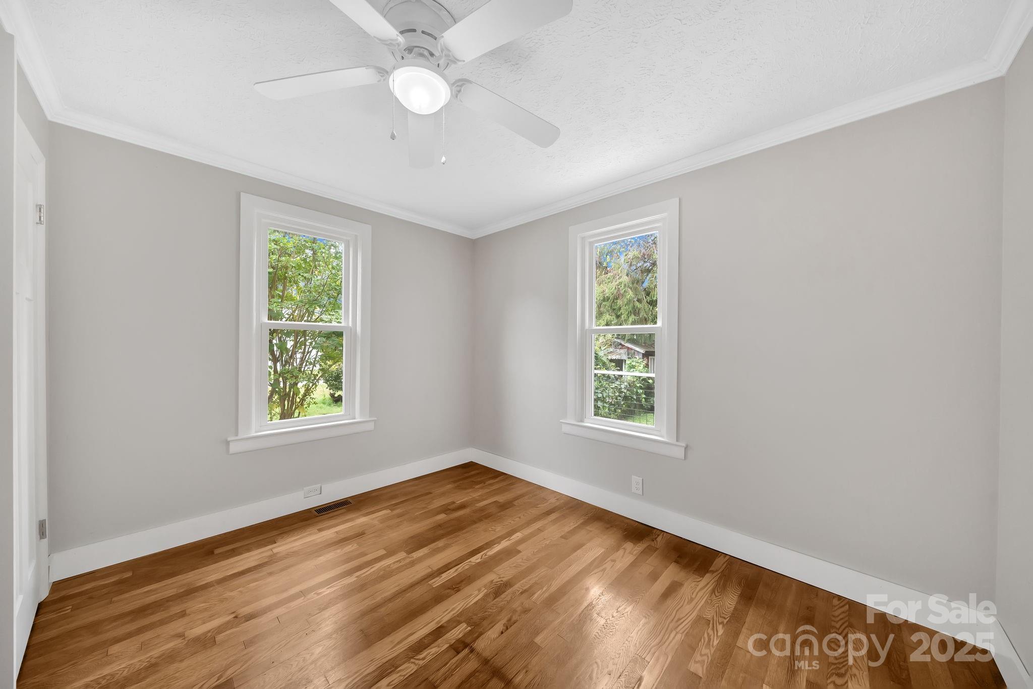 95 Whitmire Street Brevard, NC 28712 - Photo 19 of 34 a view of an empty room with wooden floor and a window