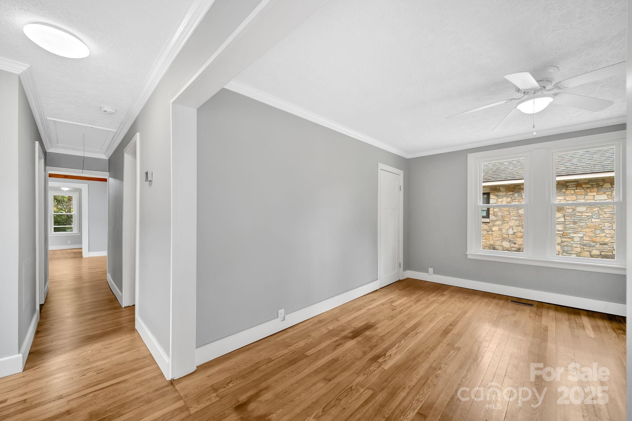 95 Whitmire Street Brevard, NC 28712 - Photo 3 of 34 a view of an empty room with wooden floor and a window