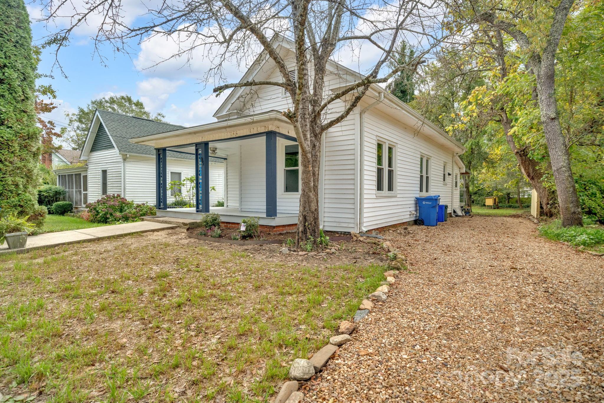 95 Whitmire Street Brevard, NC 28712 - Photo 33 of 34 a view of a white house with a large tree and plants