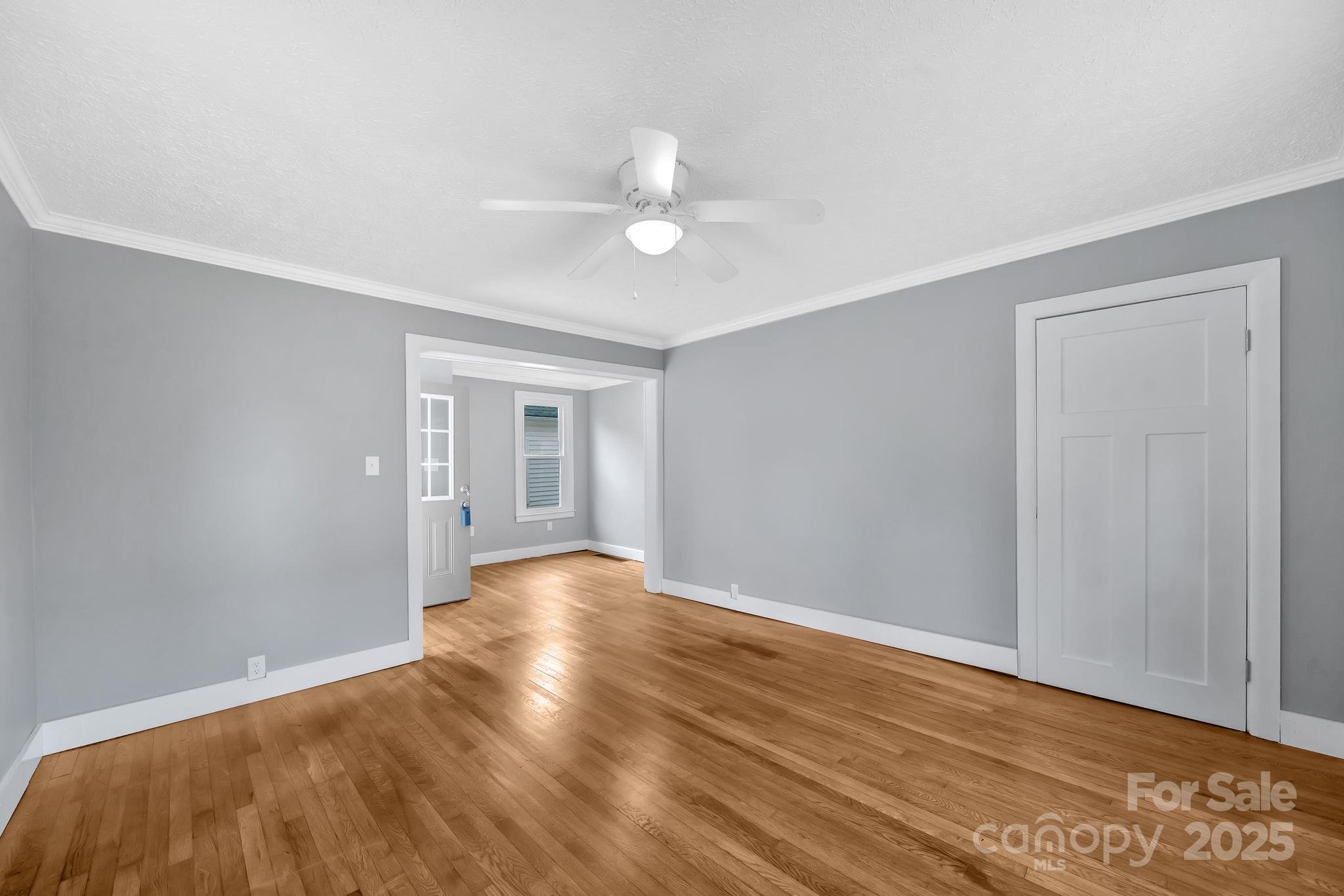 95 Whitmire Street Brevard, NC 28712 - Photo 6 of 34 a view of an empty room with wooden floor and a ceiling fan