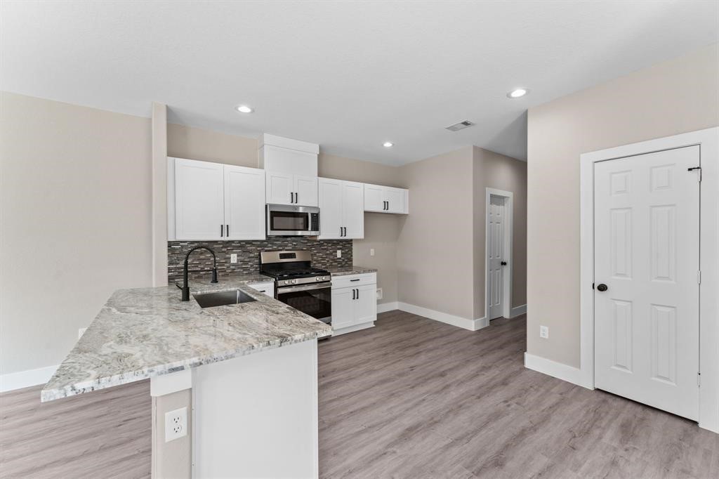 7311 Sandra Street, Unit B Houston, TX 77028 - Photo 3 of 8 a kitchen with granite countertop a sink a counter top space stainless steel appliances and cabinets