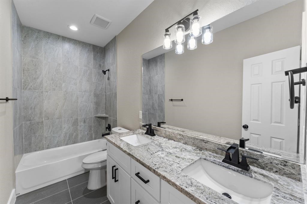 7311 Sandra Street, Unit B Houston, TX 77028 - Photo 4 of 8 a bathroom with a granite countertop sink a toilet and shower
