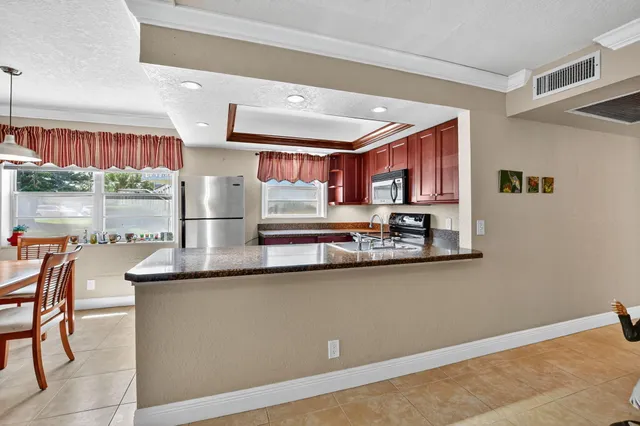 a kitchen with stainless steel appliances granite countertop a sink a stove and a refrigerator