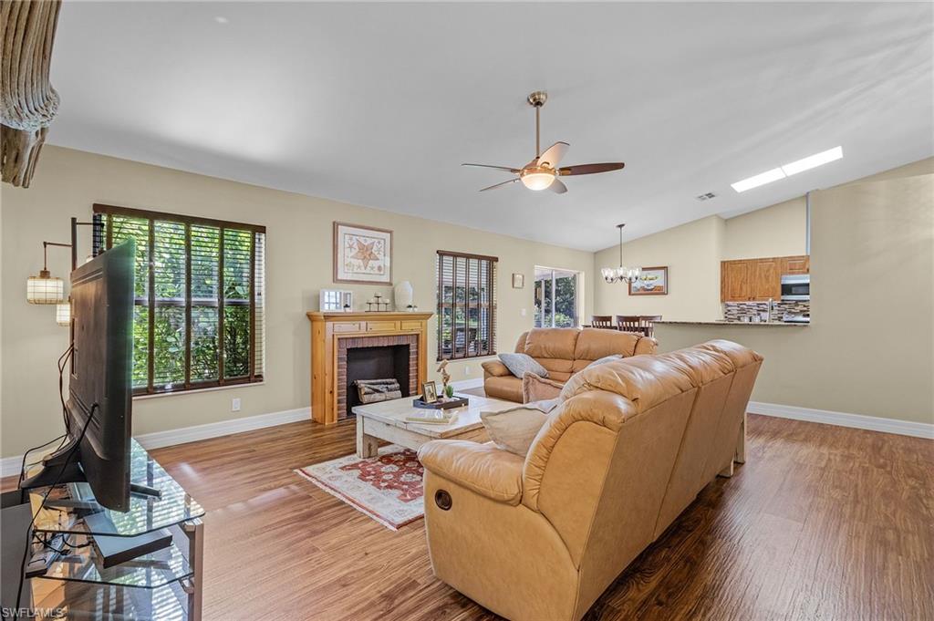 128 Plantation Circle Naples, FL 34104 - Photo 11 of 27 a living room with furniture a fireplace and a chandelier
