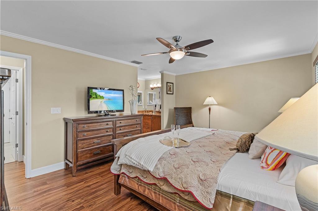 128 Plantation Circle Naples, FL 34104 - Photo 13 of 27 a bedroom with a bed and wooden floor