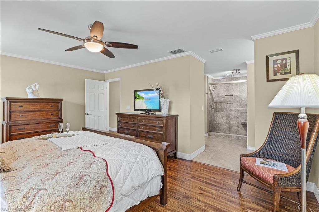 128 Plantation Circle Naples, FL 34104 - Photo 14 of 27 a bedroom with a bed and a chair
