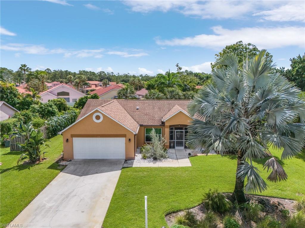 128 Plantation Circle Naples, FL 34104 - Photo 23 of 27 a front view of a house with garden
