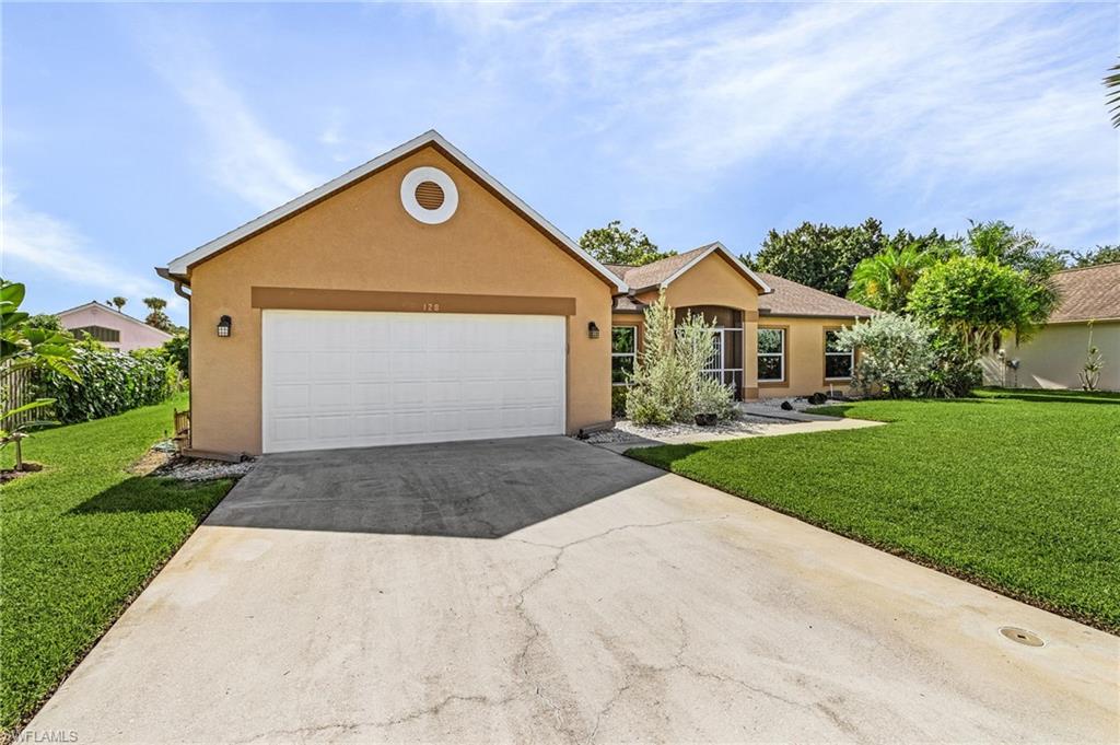 128 Plantation Circle Naples, FL 34104 - Photo 27 of 27 a front view of a house with a yard and garage
