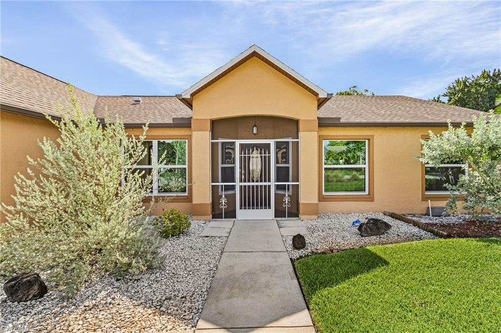 128 Plantation Circle Naples, FL 34104 - Photo 3 of 27 a front view of a house with garden