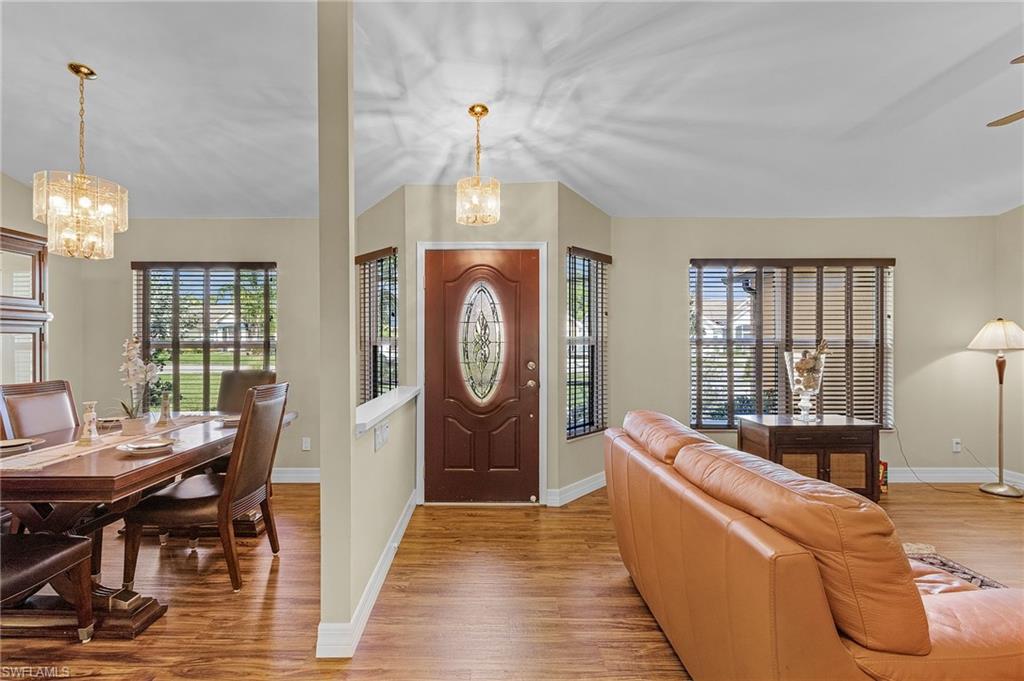 128 Plantation Circle Naples, FL 34104 - Photo 4 of 27 a living room with furniture a dining table and a chandelier