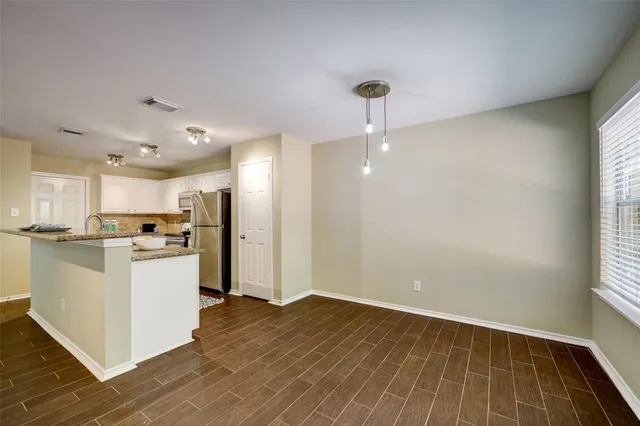 a view of kitchen with wooden floor and electronic appliances