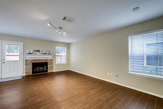 a view of an empty room with a fireplace and a window