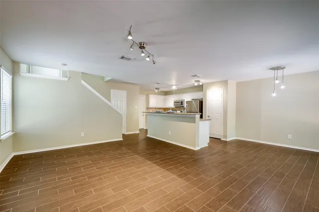 a view of a kitchen with a sink dishwasher refrigerator and white cabinets