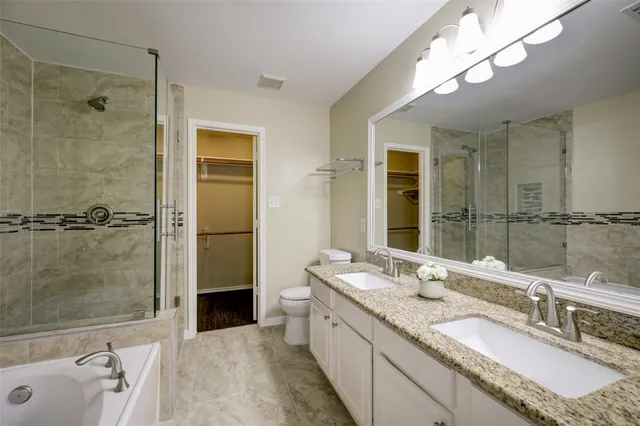 a bathroom with a granite countertop double vanity sink and mirror