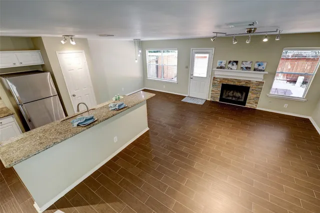 a large hall with stainless steel appliances wooden floor and a fireplace