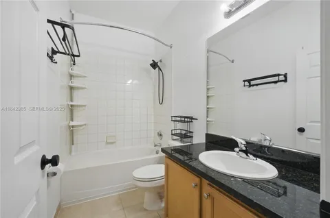 a bathroom with a granite countertop sink toilet mirror and shower