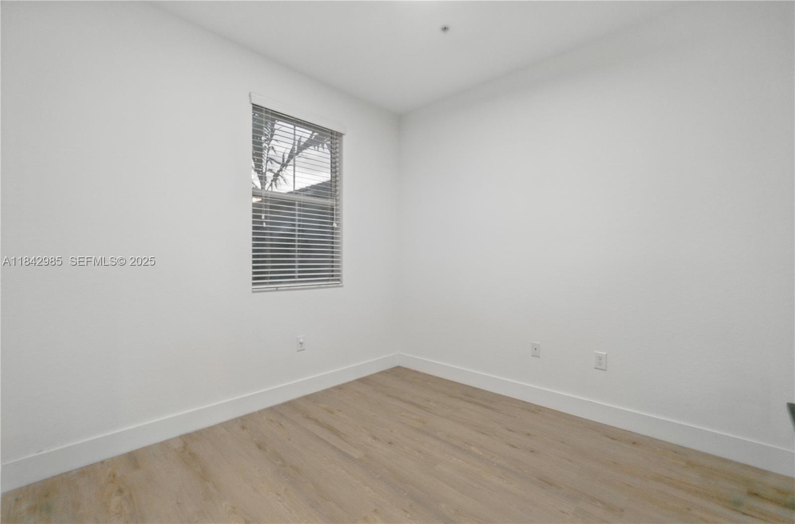 2851 Prospect Road, Unit 307 Tamarac, FL 33309 - Photo 12 of 21 a view of an empty room with wooden floor and a window