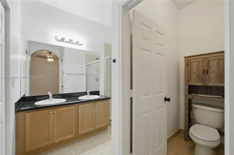 a bathroom with a granite countertop sink toilet and shower