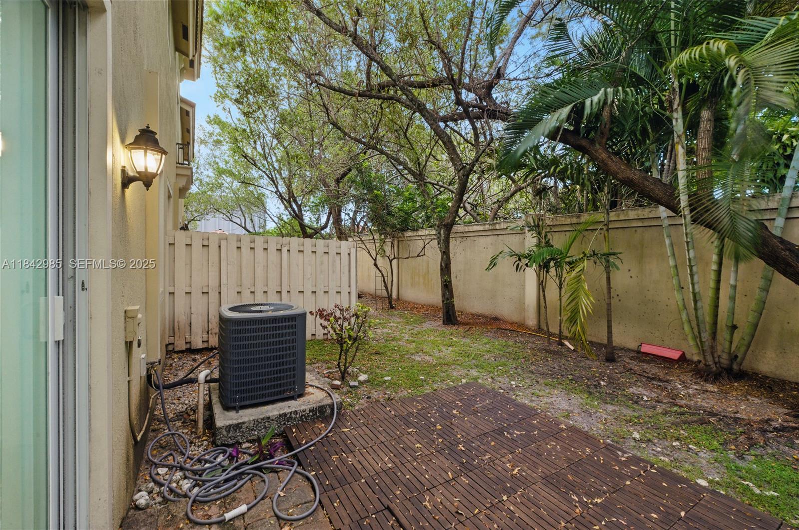 2851 Prospect Road, Unit 307 Tamarac, FL 33309 - Photo 21 of 21 a view of backyard with wooden fence and a large tree