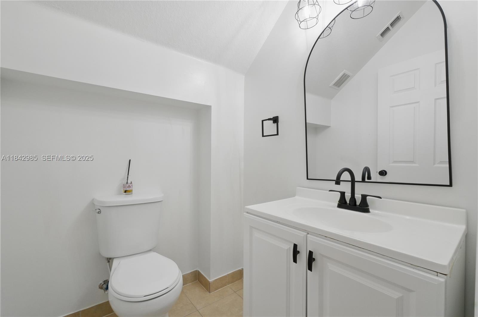 2851 Prospect Road, Unit 307 Tamarac, FL 33309 - Photo 5 of 21 a bathroom with a sink a toilet and mirror