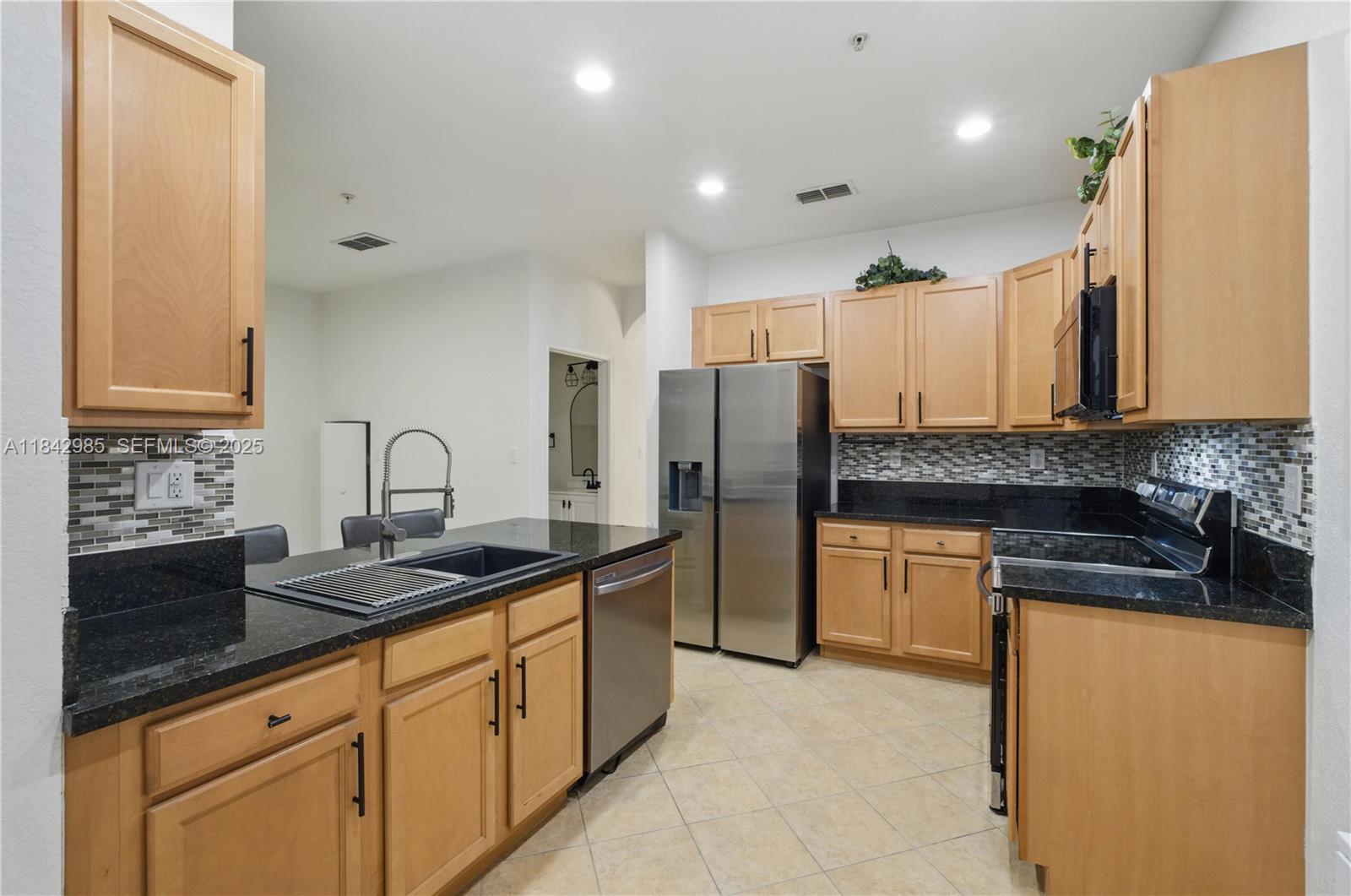 2851 Prospect Road, Unit 307 Tamarac, FL 33309 - Photo 6 of 21 a kitchen with stainless steel appliances granite countertop a sink a refrigerator and a granite counter tops