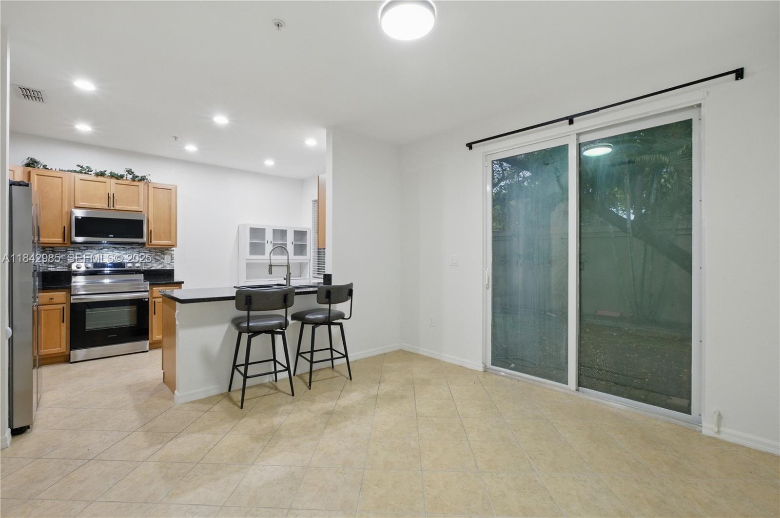 2851 Prospect Road, Unit 307 Tamarac, FL 33309 - Photo 7 of 21 a kitchen with a refrigerator and a stove top oven