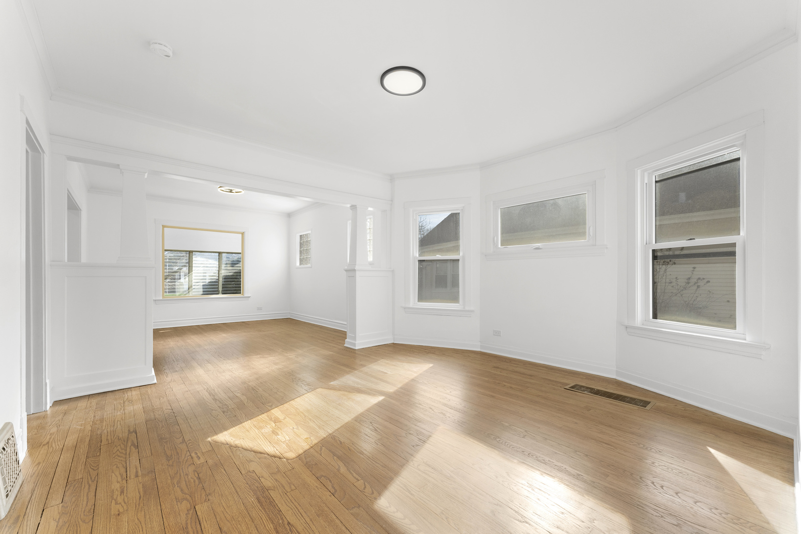 1035 South Ridgeland Avenue Oak Park, IL 60304 - Photo 7 of 33 a view of an empty room with wooden floor and a window