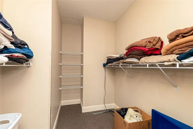 a view of walk in closet with clothes and shoes