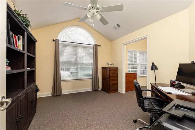 a view of a workspace with furniture and a window