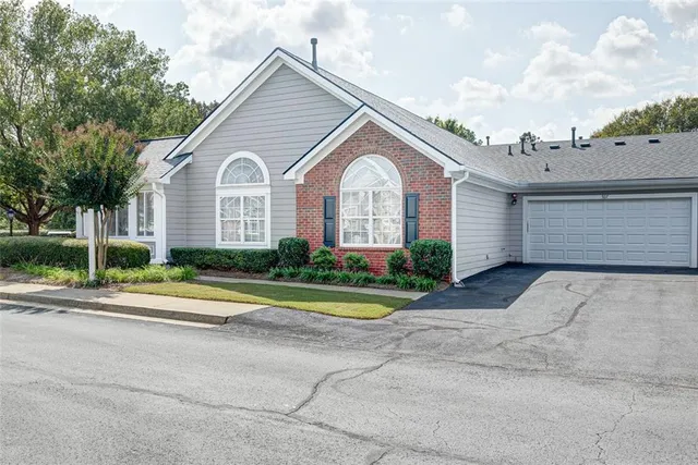 a front view of a house with a yard and trees