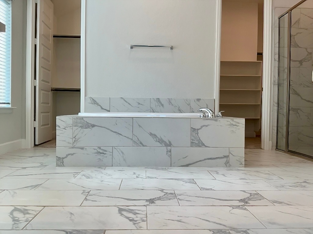 1636 Laverne Mitchell Street Leander, TX 78641 - Photo 11 of 20 Bathroom with a two walk-in closets, a marble finish shower, a garden tub, and light marble finish flooring