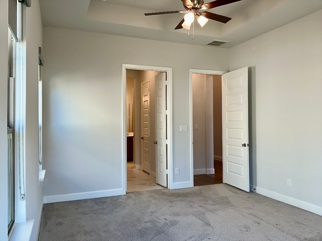 1636 Laverne Mitchell Street Leander, TX 78641 - Photo 12 of 20 Bedroom 2 with carpet, ceiling fan, a raised ceiling, and ensuite bathroom