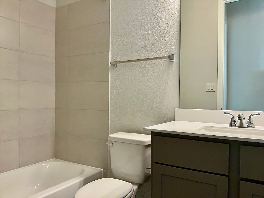 1636 Laverne Mitchell Street Leander, TX 78641 - Photo 15 of 20 Bathroom with a textured wall, vanity, and shower / washtub combination