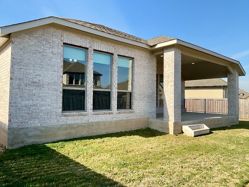 1636 Laverne Mitchell Street Leander, TX 78641 - Photo 20 of 20 View of back of property with brick siding, a yard, and a patio
