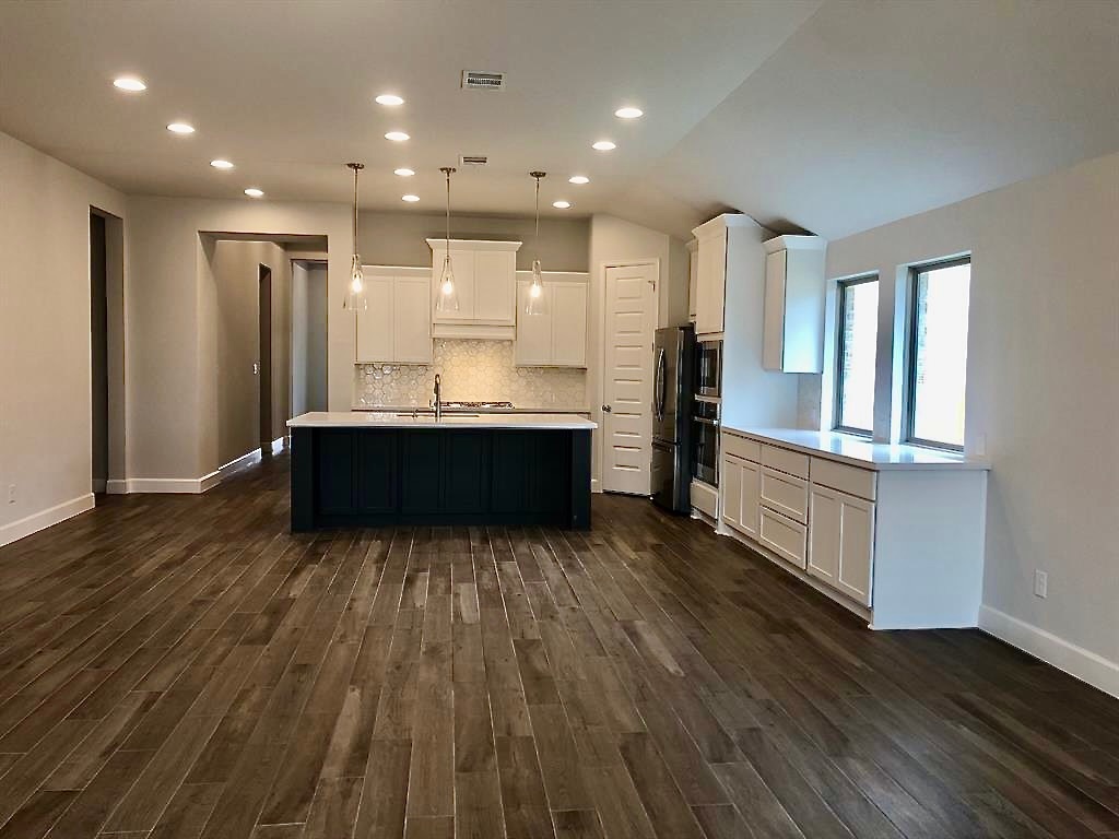 1636 Laverne Mitchell Street Leander, TX 78641 - Photo 5 of 20 Kitchen featuring white cabinetry, recessed lighting, dark cabinetry, pendant light fixtures, under cabinet lighting and decorative backsplash