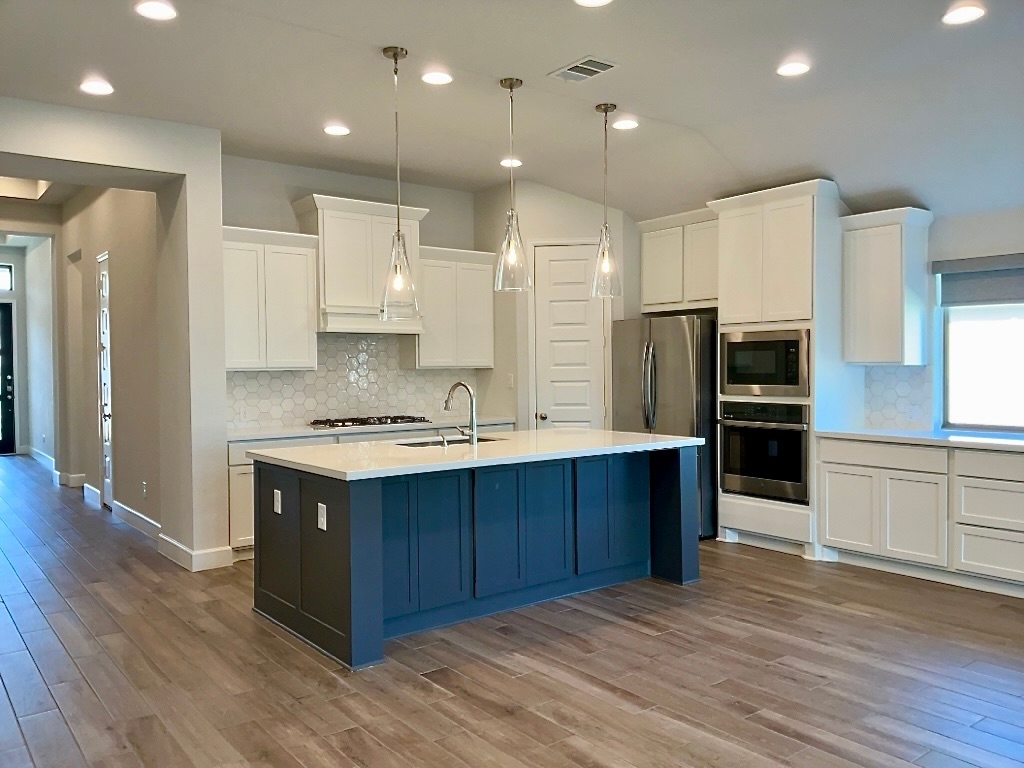 1636 Laverne Mitchell Street Leander, TX 78641 - Photo 6 of 20 Kitchen with white cabinets, tasteful backsplash, appliances with stainless steel finishes, decorative light fixtures, and recessed lighting